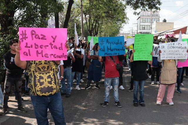 Personas con cartulinas en mano durante manifestación en la calle 