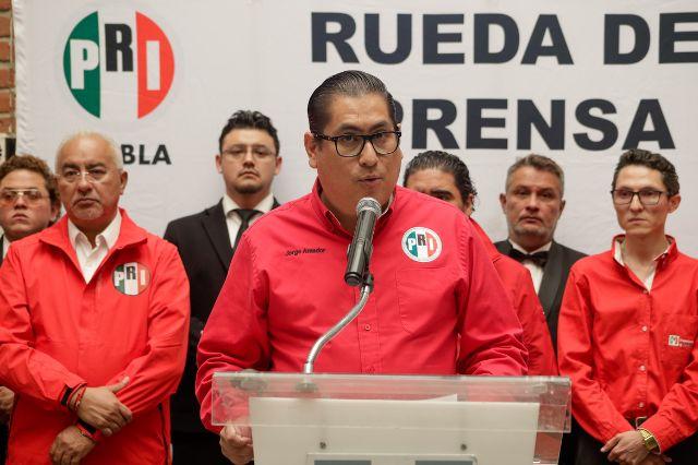Personas en conferencia de prensa con camisa del PRI