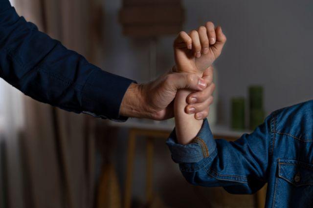 Persona sosteniendo el brazo de un menor de edad