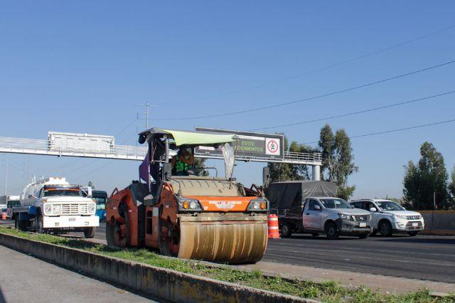 Maquinaria sobre la Autopista México-Puebla realizando obras de pavimentación 