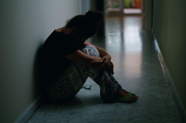 Mujer sentada en un pasillo oscuro