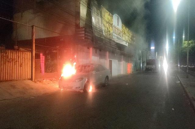 Auto incendiándose afuera de bar 