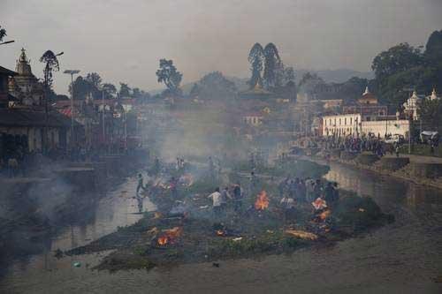 Columnas de humo se alzan en un río del distrito de Pashupatinath, en Katmandú, donde familias creman los restos de víctimas del terremoto para alejar el riesgo de infecciones Foto Ap