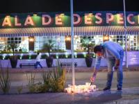 Una persona enciende una veladora frente al bar Sala de Despecho, donde tres personas fueron asesinadas