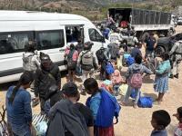 Personas con mochila abordando camioneta blanca 