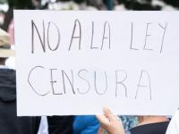 Persona sosteniendo una cartulina con la leyenda No a la Ley Censura 