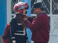 Hombre pone casco de motociclista a una mujer