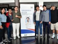 Alumnos BUAP junto a cartel de la conferencia